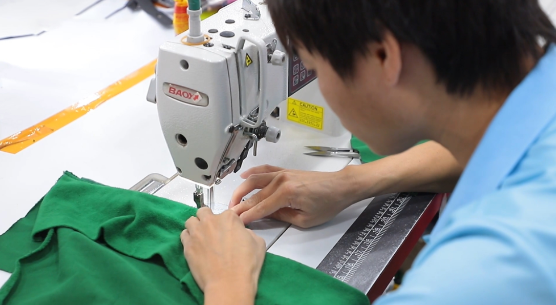 A close-up of skilled hands crafting high-quality golf apparel with precision stitching, showcasing the dedication to detail in OEM/ODM services.